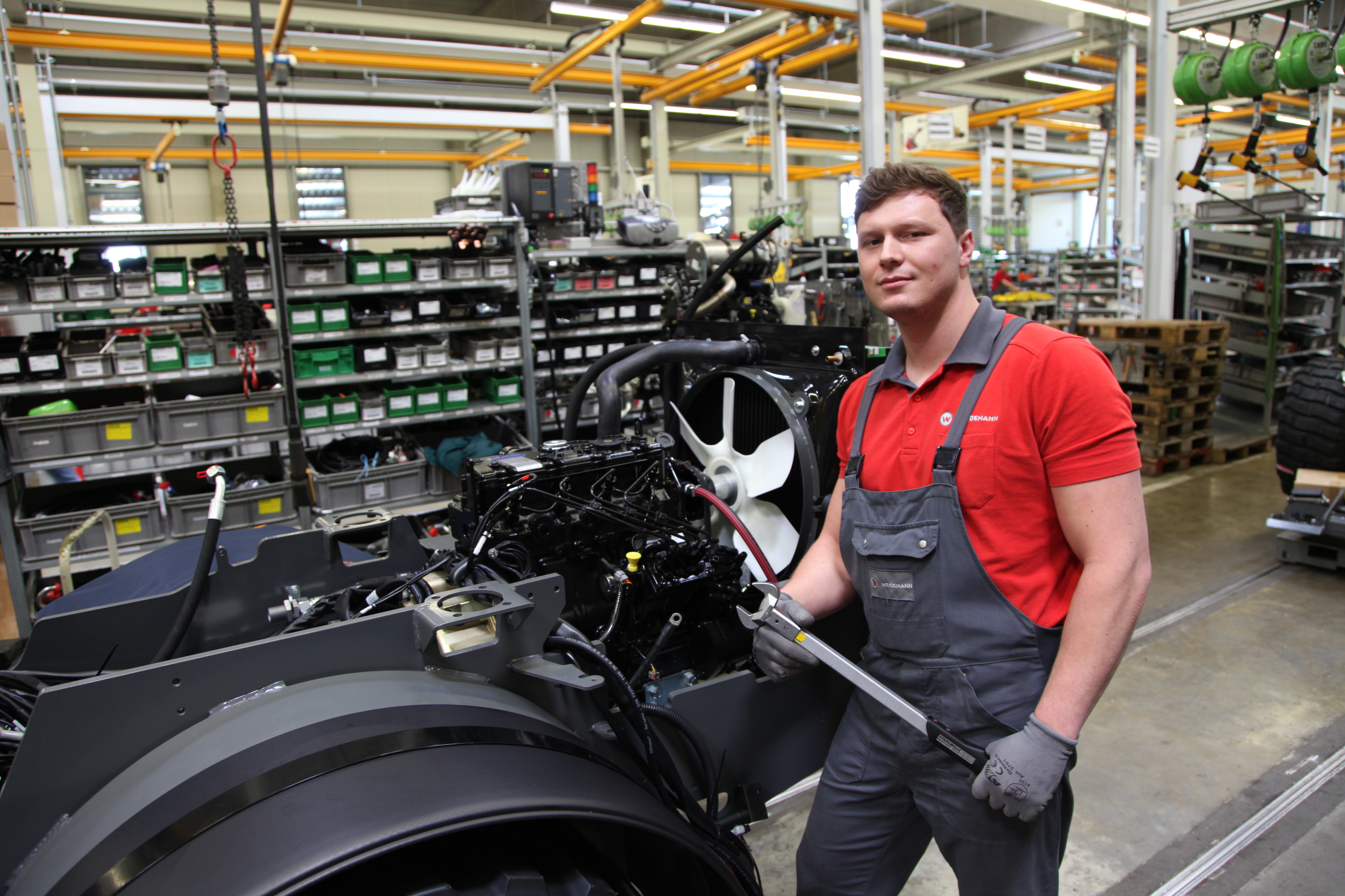 Weidemann Mitarbeiter in der Produktion schraubt an einer Maschine