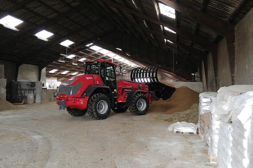 Weidemann Teleskopradlader 9580T im Einsatz mit Greifschaufel in einer landwirtschaftlichen Halle landwirtschaftlichen Halle