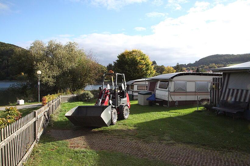 Weidemann Hoftrac 1160 mit Fahrerschutzdach im Einsatz mit Leichtgutschaufel auf einem Campingplatz