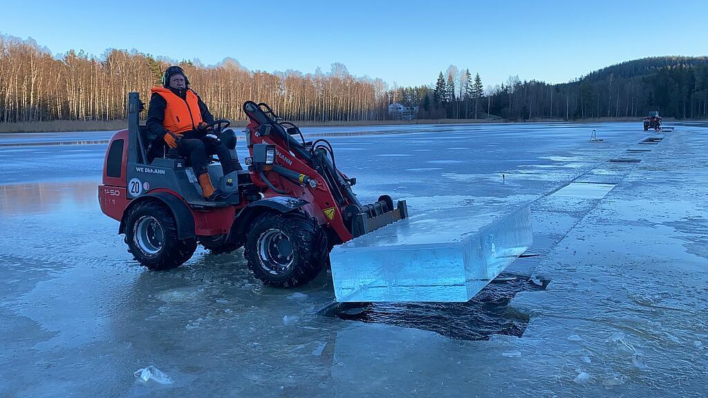 Weidemann Hoftrac 1250 im Einsatz mit einer Palettengabel auf dem ein Eisblock liegt