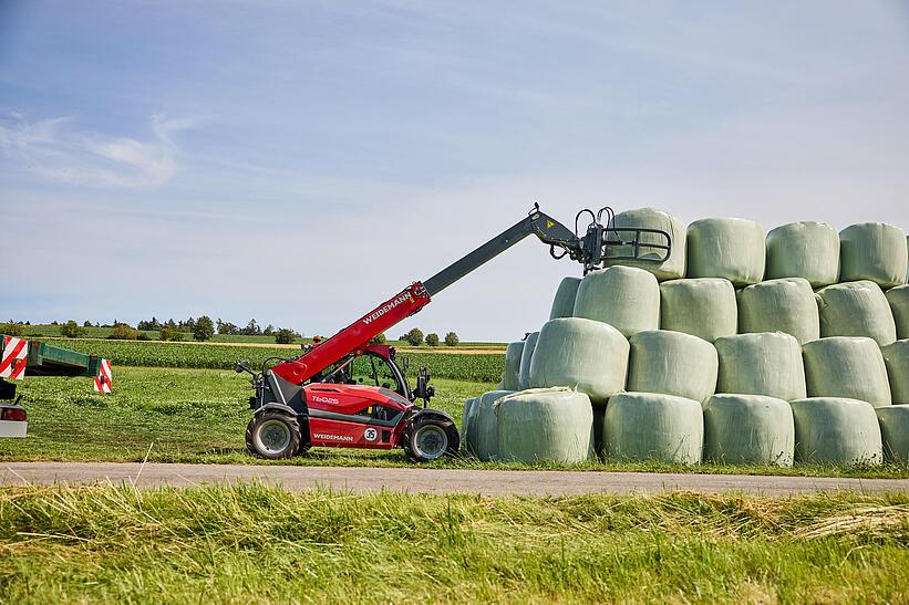 Weidemann Teleskoplader T6025 mit Ballengreifschaufel auf einem landwirtschaftlichen Betrieb im Einsatz