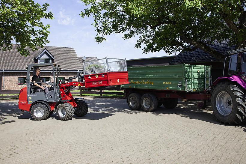 Ein Weidemann Hoftrac 1160e mit Fahrerschutzdach im Einsatz mit Palettengabel