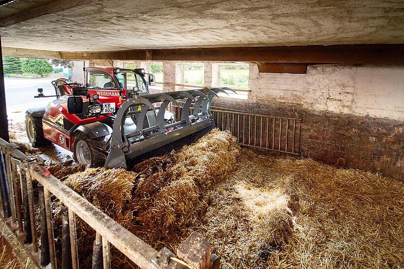 Weidemann Teleskoplader T6025 mit Greifschaufel auf einem landwirtschaftlichen Betrieb im Einsatz