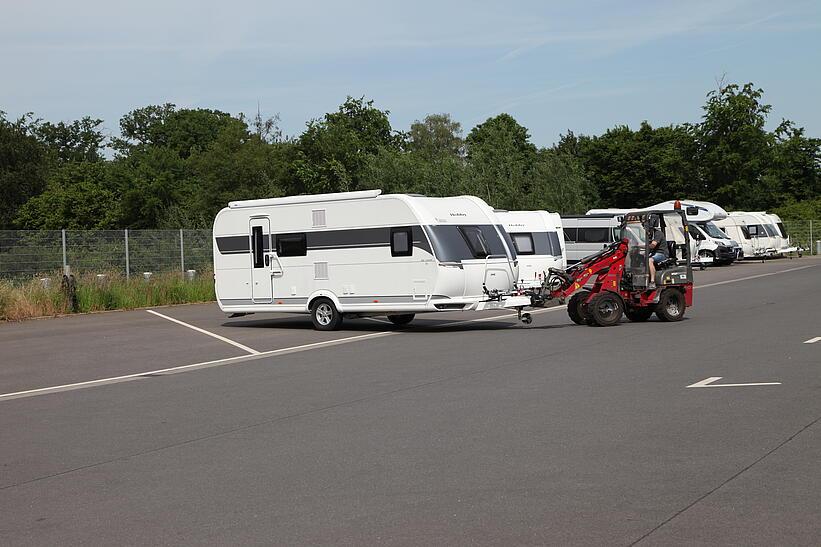 Weidemann Hoftrac 1140 rangiert mit Wohnwagen